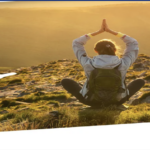 a woman sitting on a hill with her hands together